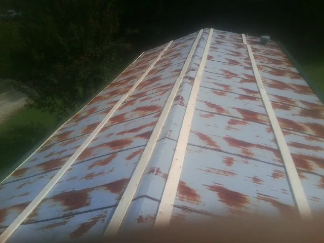Rusted metal roof panels with new wood purlins before replacement — Storm Damage Roof Repair in Coburn by Roofing Brothers